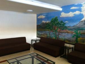 a waiting room with a painting on the wall at Hotel Dos Naciones in Mexico City