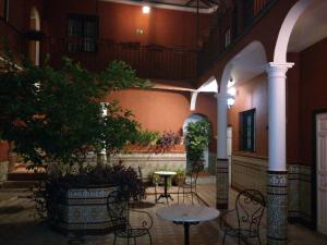 a courtyard with tables and chairs and a tree at Al Andalus Jerez in Jerez de la Frontera