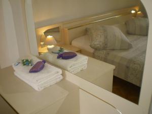 a bedroom with towels and a bed with a mirror at Apartments Villa Jagoda in Rab