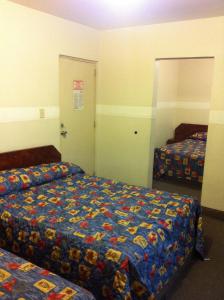 una habitación de hotel con 2 camas y una puerta a un dormitorio en Hotel Dos Naciones, en Ciudad de México