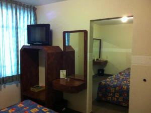 a room with a mirror and a tv and a bed at Hotel Dos Naciones in Mexico City