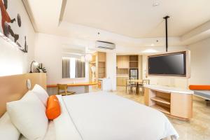 a bedroom with a large bed and a flat screen tv at HARRIS Resort Batam Waterfront in Sekupang