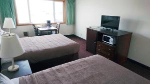 a hotel room with two beds and a flat screen tv at Silver Sands in Rockaway Beach