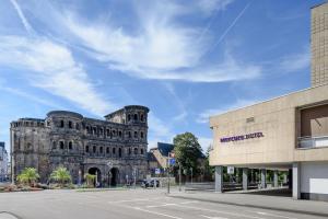 a large building with a clock on the side of it at Mercure Hotel Trier Porta Nigra in Trier