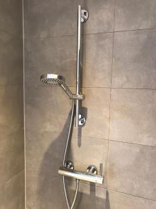 La salle de bains est pourvue d'une douche avec un pommeau de douche. dans l'établissement Villa Oscar with sauna in Winterswijk, à Winterswijk