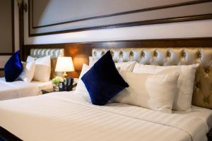 河內的住宿－Alisa Hotel & Spa，一间卧室配有两张带蓝白色枕头的床