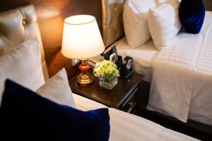 a hotel room with two beds and a lamp on a table at Alisa Hotel & Spa in Hanoi