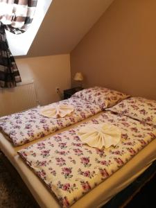 um quarto com duas camas com flores em Apartman Paula 1 em Podhájska