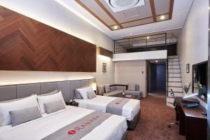 Habitación de hotel con 2 camas y escritorio en Pyeongchang Ramada Hotel & Suite by Wyndham, en Pyeongchang