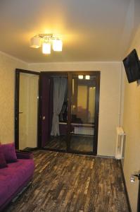 ブリャンスクにあるАпартаменты в центре на Авиационной 19のリビングルーム(紫色のソファ、窓付)