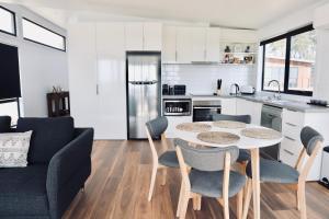a kitchen and living room with a table and chairs at By Moonlight in Wattle Hill +11 photos