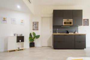 a kitchen with black cabinets and a microwave at HoMilan in Milan
