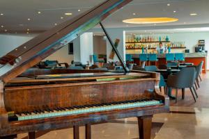 a piano in a restaurant with a bar at Queens Bay Hotel in Paphos
