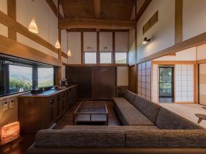 een woonkamer met een bank en een tafel bij Okuhita Onsen Umehibiki in Hita