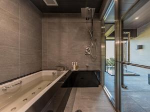a large bathroom with a tub and a shower at Okuhita Onsen Umehibiki in Hita
