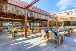 an outdoor dining area with tables and chairs at Stella Village Seaside Hotel in Hersonissos