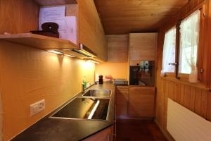 uma pequena cozinha com um lavatório e um fogão em Claquevent em Rougemont
