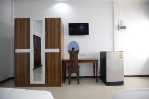 a room with a desk and a tv and a refrigerator at SABUN-NGA HOSTEL in Chiang Rai