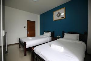 - 2 lits dans une chambre aux murs bleus dans l'établissement SABUN-NGA HOSTEL, à Chiang Rai