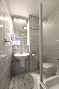 a bathroom with a sink and a toilet and a shower at LAT Hotel & Apartmenthaus Berlin in Eisenhüttenstadt
