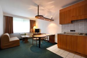 a kitchen with a table and a dining room at LAT Hotel & Apartmenthaus Berlin in Eisenhüttenstadt