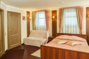a bedroom with a bed and a chair at Na Ilyinke in Nizhny Novgorod