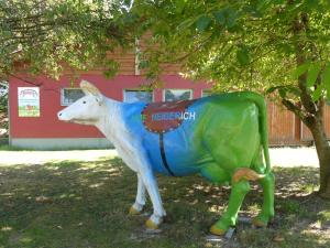 una estatua de una vaca delante de un edificio en Ferienwohnungen Hof Heiderich, en Beerfelden