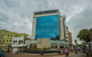 a tall glass building on a city street at The Blue Lagoon Hotel Premium in Cuttack