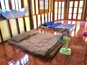 Habitación con 2 camas y ventilador en el suelo en Grandma's House, en Nakhon Nayok
