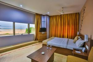 a hotel room with a bed and a view of the beach at The Blue Lagoon Hotel Premium in Cuttack