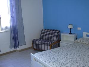 a bedroom with a bed and a chair and a window at Lerici al bacio in Lerici