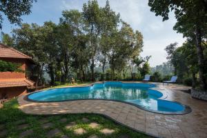an image of a swimming pool in a yard at Indeevara Luxury Resort and Spa, Wayanad in Vythiri