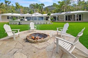 een achtertuin met twee stoelen en een vuurplaats bij La Boheme Whitsunday in Airlie Beach