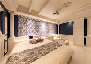 a bedroom with a large bed and a blue wall at HOTEL Eldia Japanese Modern (Adult Only) in Gyōda
