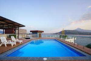 a pool on the roof of a house with a view of the water at Intouch Riverside Hotel in Pakse