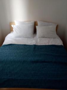 a bed with a blue blanket and white pillows at city center apartment 1 in Niš