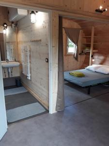 een kleine kamer met een bed en een wastafel bij Domaine de l'Ours / Camping Lodge in Saint-Urcize