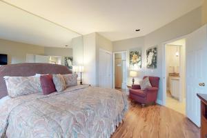 a bedroom with a large bed and a red chair at Ponderosa Views in Bend