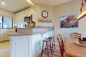a kitchen with a counter and a table and a clock at Ponderosa Views in Bend