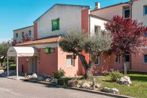 un hotel con un árbol frente a un edificio en ibis Styles Marseille Plan de Campagne, en Les-Pennes-Mirabeau