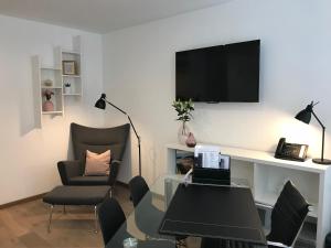 a living room with a table and a tv on a wall at Antwerp Business Suites in Antwerp