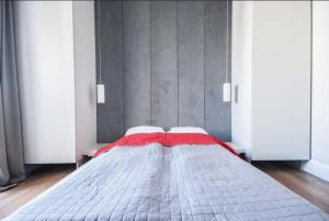 ワルシャワにあるHarmony Heights Apartmentのベッドルーム1室(赤い毛布付きのベッド1台付)