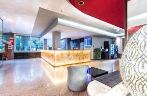 a lobby with a gold counter and chairs at Antony Hotel - Venice Airport in Campalto