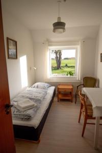 Habitación pequeña con cama y ventana en Shalom, en Gjerlev