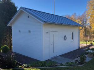 a white garage with a door in a yard at Lakeview Studio in Stavsjo +14 photos