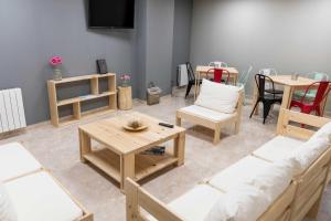 Una sala de estar con un sofá y sillas y una mesa. en Alda Estella Hostel, en Estella