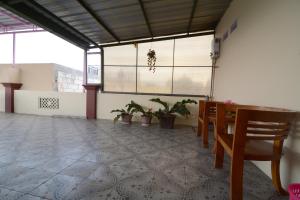 a room with a table and chairs and windows at Villa Amanah in Batu