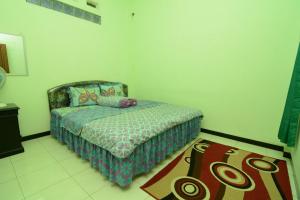 a small bedroom with a bed and a rug at Villa Amanah in Batu