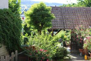 un jardin fleuri et une maison avec un toit dans l'établissement Casa Stetten, à Lörrach