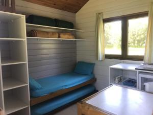 a small room with a blue bench and a window at Domaine de l'Ours / Camping Lodge in Saint-Urcize